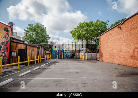 Paintings on wall along a sidewalk in Dallas Deep Ellum. Stock Photo