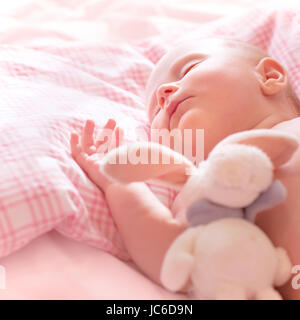 Newborn baby sleeps, relaxing in the bed, adorable healthy child dreaming, safe childhood concept Stock Photo