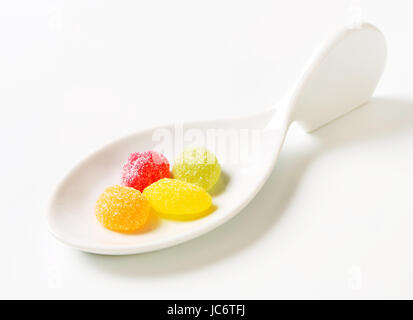 Fruit-shaped gummy candy on ceramic spoon Stock Photo