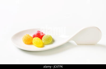 Fruit-shaped gummy candy on ceramic spoon Stock Photo