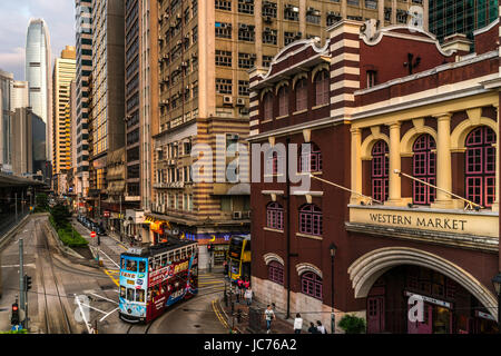 Beautiful street view featuring the Western Market building in Hong Kong and the popular form of transportation, the double-deck trams. Stock Photo