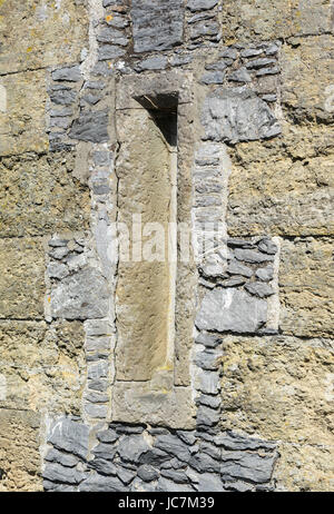 Arrowslit on a stone castle wall in the UK. Arrow slit. Stock Photo