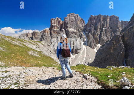 hiker on footpath  in Sella mountain, on background Mezdi valley and Piz da Lech peak, south Tyrol, Italy Stock Photo