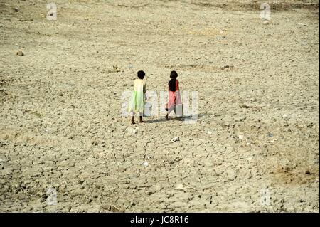 Allahabad, Uttar Pradesh, India. 14th June, 2017. Children carrying drinking water as they passed trough parshed a pond during summer in Allahabad Credit: Prabhat Kumar Verma/ZUMA Wire/Alamy Live News Stock Photo