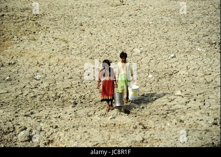 Allahabad, Uttar Pradesh, India. 14th June, 2017. Children carrying drinking water as they passed trough parshed a pond during summer in Allahabad Credit: Prabhat Kumar Verma/ZUMA Wire/Alamy Live News Stock Photo