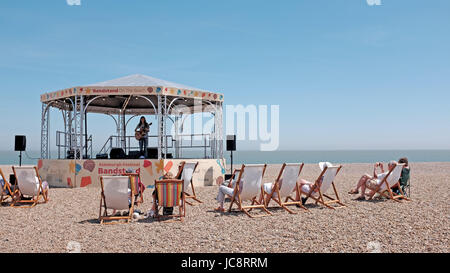 Aldeburgh Suffolk, UK. 14th June, 2017. Visitors enjoy the hot sunny weather and a concert in the bandstand on the beach along Aldeburgh seafront which is part of their annual music and arts festival . Hot sunny weather is forecast to spread across Britain again in the next few days with temperatures reaching as high as 28 degrees in some parts Credit: Simon Dack/Alamy Live News Stock Photo