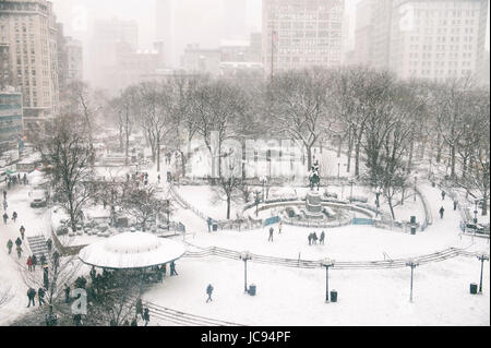 Snowy winter scene with trails left by pedestrians in the snow in Union Square as a blizzard overtakes New York City