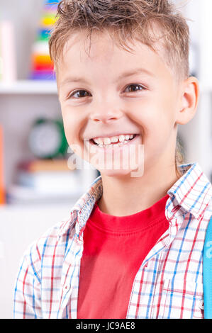 close up portrait of happy smiling young boy looking at camera. Child in the classroom or home. Stock Photo