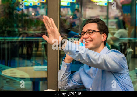 handsome young successful man doing a welcome gesture. Inviting businessman.Hello I'm  Here Stock Photo