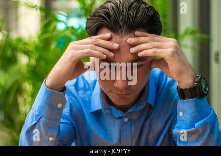 Sad, tired or depressed businessman at the desk. Business man with problems and stress in the office Stock Photo