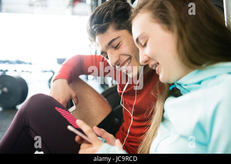Fit couple in modern crossfit gym with smartphone. Stock Photo