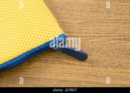 Yellow Pocket Bag and Blue Zipper on A Wooden Table with Copy Space for Text Decorated. Stock Photo