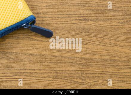 Yellow Pocket Bag and Blue Zipper on Wooden Table with Copy Space for Text Decorated. Stock Photo