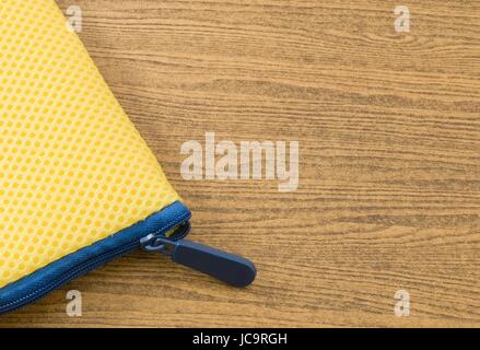 Yellow Pocket Bag and Blue Zipper on A Wooden Table with Copy Space for Text Decorated. Stock Photo