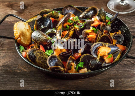 Skillet of marinara mussels on rustic background with copyspace Stock Photo