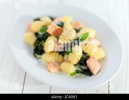 Italian gnocchi pasta, or dumplings, sauteed and served with diced salmon and basil Stock Photo