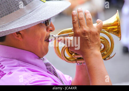 Close up of a local man playing trumpet during Festival of the Virgin de la Candelaria in Lima, Peru. The core of the festival is dancing and music pe Stock Photo