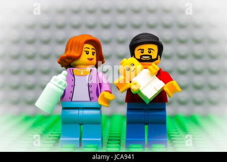 Tambov, Russian Federation - September 21, 2016 Lego family - father, mother and baby minifigures. Baby in the daddy arms, mother with baby bottle. St Stock Photo