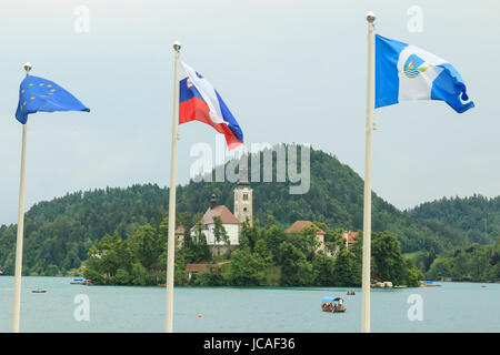 Bled, Slovenia - June 3, 2017: Close up of the church in the center of Bled Lake with several tourists on a boat Stock Photo