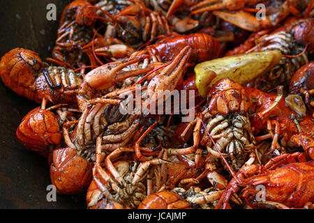 Portion of cooked ready to eat red crawfish (crayfish) with lemon in frying pan close up, high angle view Stock Photo