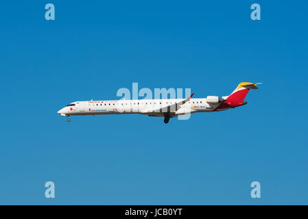 Madrid, Spain - May 22, 2017: Iberia Bombardier CRJ 1000 is landing in Madrid Barajas airport on May 22, 2017. Iberia is the  flag carrier and the lar Stock Photo