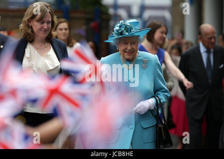 Queen Elizabeth II smiles as she walks past flag-waving school children after visiting Mayflower Primary School during a visit to Poplar in Tower Hamlets in East London, as part of commemorations to mark the centenary of the bombing of Upper North Street School during the First World War.