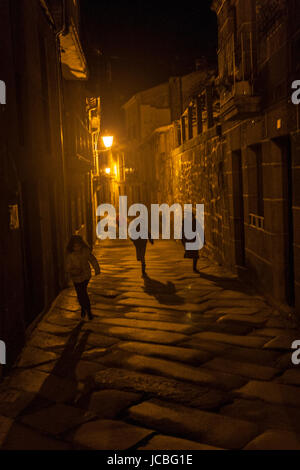 Children running along a stoned street in Allariz at night, province of Ourense, Galicia, Spain. Stock Photo