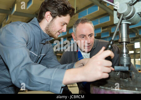 male engineer in factory using milling machine Stock Photo
