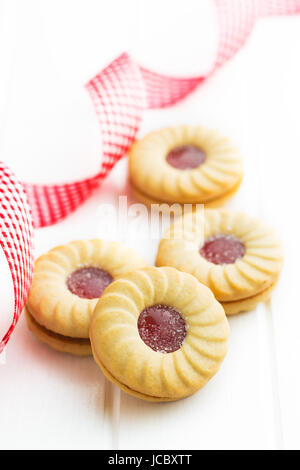 Sweet biscuits with jam on kitchen table. Stock Photo