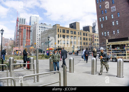 when trains arrive & leave new subway station people scurry to & from escalator entrance at 34th Street end of looming Hudson Yards construction Stock Photo