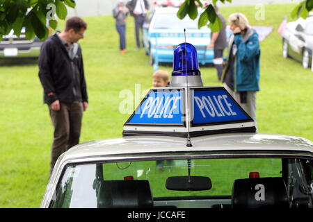 Beaulieu, Hampshire, UK - May 29 2017: Police insignia and blue flashing light on top of a white 1972 MG MGB GT V8, with unidentified people in backgr Stock Photo