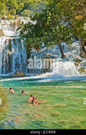 KRKA,CROATIA - AUGUST 17, 2014. Tourists enjoy a bath at Krka waterfalls in Krka National park, great attraction near Sibenik. Krka river forms 17 waterfalls in an area of 400 mt. in length and 100 mt. in width. Stock Photo