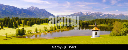Panorama Landschaft in Bayern mit Blick über den Hegratsrieder Weiher auf die Bergkette der Allgäuer Alpen Stock Photo