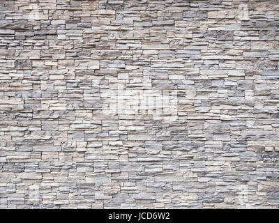 structure multicolored stone wall laid down like bricks with cement joints. Stock Photo