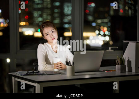 Businesswoman working overtime at night Stock Photo