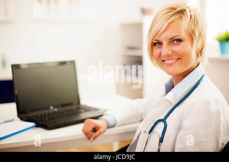 Young female doctor sitting in her office Stock Photo