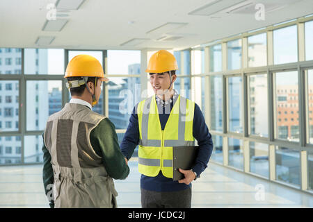 Two smiling architects making a handshake Stock Photo