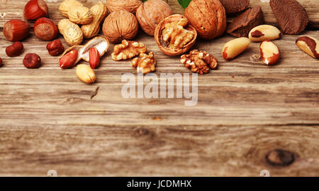 Selection of festive fresh nuts both shelled and in their shells on rustic wood with copyspace including almonds, hazelnuts, brazil nuts, peanuts and walnuts Stock Photo