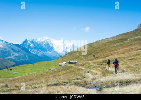 COL DE BALME, FRANCE - SEPTEMBER 01: Backpackers approraching chalet with Mont Blanc in the background. The area is a stage of the popular Mont Blanc tour. September 01, 2014 in Col de Balme. Stock Photo