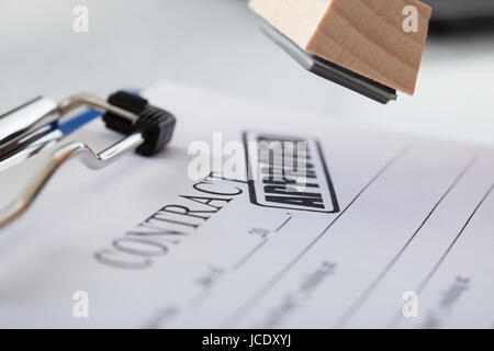 Close-up Of Business Man Hand Pressing Rubber Stamp On Document Stock Photo