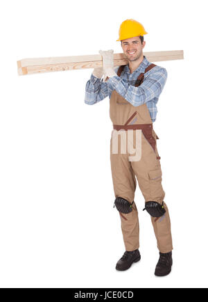 Worker wearing hard hat and carrying timber. Isolated on white Stock Photo