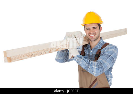 Worker wearing hard hat and carrying timber. Isolated on white Stock Photo