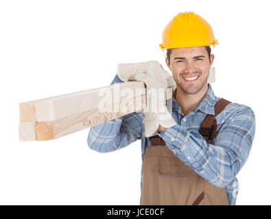 Worker wearing hard hat and carrying timber. Isolated on white Stock Photo