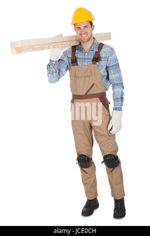 Worker wearing hard hat and carrying timber. Isolated on white Stock Photo