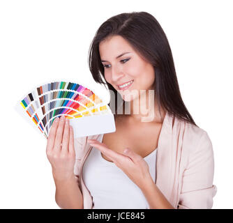 Attractive woman chooses a color scheme. Studio portrait over white Stock Photo