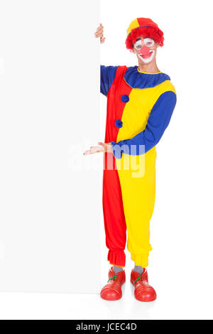 Portrait Of A Happy Joker Holding Blank Placard Over White Background Stock Photo