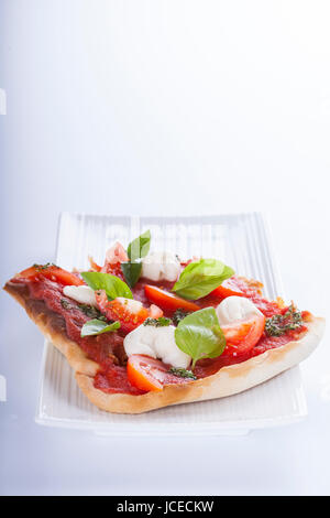 pizza pomodoro, vegetarian and homemade with mozzarella, tomatoes and basil isolated on white background Stock Photo