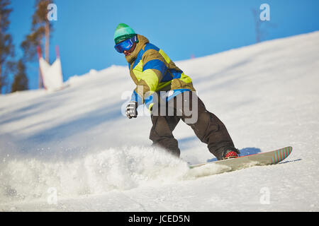 Active sportsman snowboarding in snowdrift Stock Photo