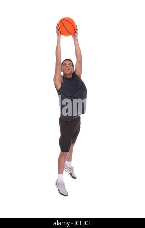 Portrait Of Basketball Sportsman Doing Slam Dank Over White Background Stock Photo