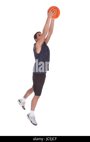 Portrait Of Basketball Sportsman Doing Slam Dank Over White Background Stock Photo